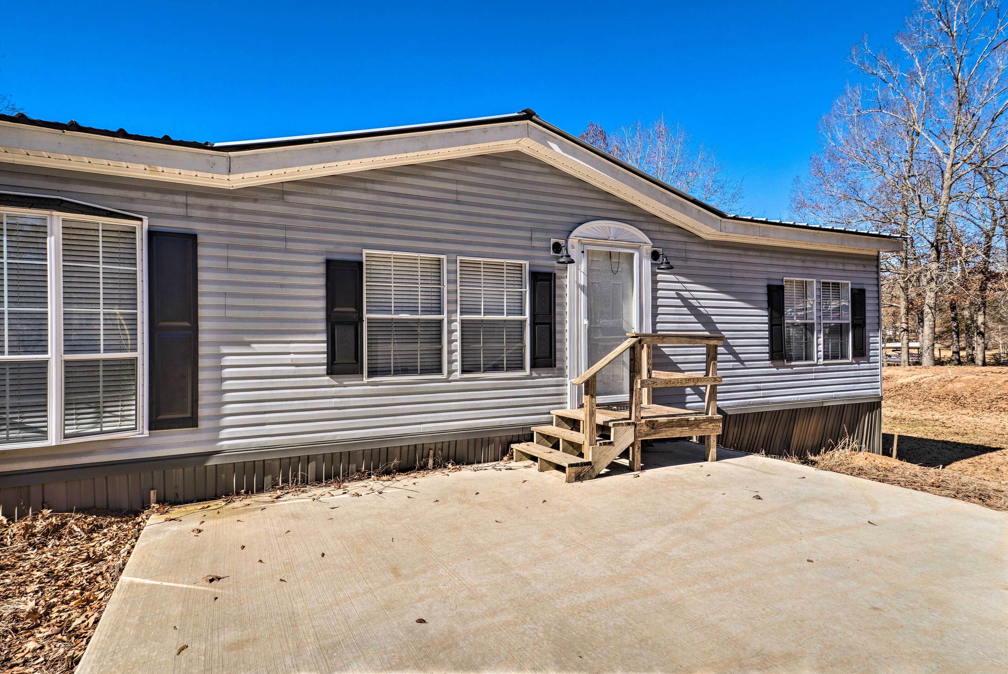 A single-story mobile home with a front porch and a concrete driveway.