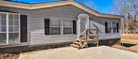 A single-story mobile home with a front porch and a concrete driveway.