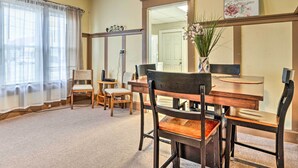 A dining area with a wooden table and chairs, a vase with flowers, and a framed quote on the wall. - Dtwn Family Home 2 Mi to Indiana Convention Center (Indianapolis)