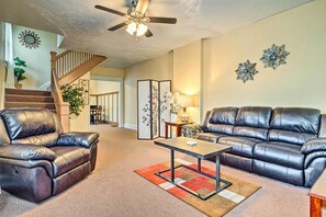 A living room with a brown leather sofa, a matching armchair, a coffee table, and a ceiling fan. - Dtwn Family Home 2 Mi to Indiana Convention Center (Indianapolis)