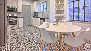 Una cocina moderna con armarios blancos, electrodomésticos de acero inoxidable y suelo estampado.