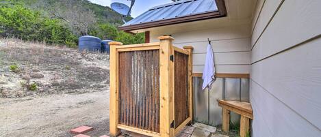 A wooden gate leading to a covered outdoor area with a stone pathway.