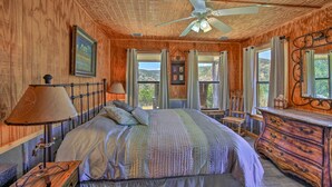 A wooden cabin bedroom with a bed, dresser, and a ceiling fan. - Two Cozy Medina Cottages, Game Room, Mountain View (Medina)