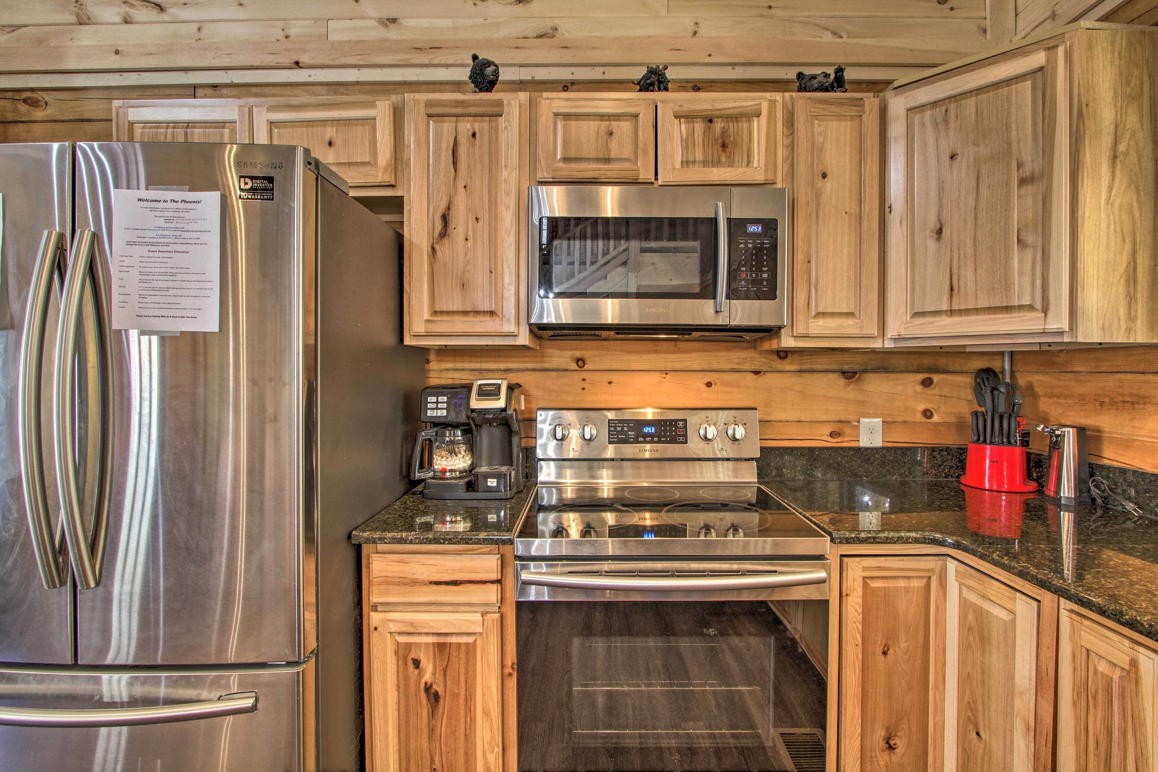 Une cuisine dotée de meubles en bois, d’appareils électroménagers en acier inoxydable, notamment un réfrigérateur, un four à micro-ondes et une cuisinière, et d’un comptoir en granit.