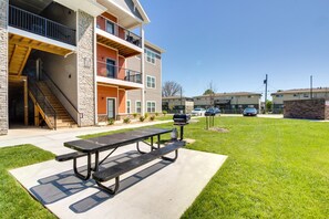 A multi-story building with a covered outdoor area featuring a picnic table and barbecue grill. - Emporia Apt w/ Playground: 2 Mi to Main Street! (Emporia)