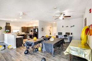 A modern living room with a dining area, kitchen, and a ceiling fan. There are balloons on the floor and a sign on the wall that says "be our guest". - Emporia Apt w/ Playground: 2 Mi to Main Street! (Emporia)