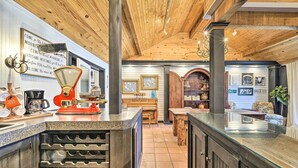 Une cuisine avec des poutres en bois, un meuble à vin et un coin café.