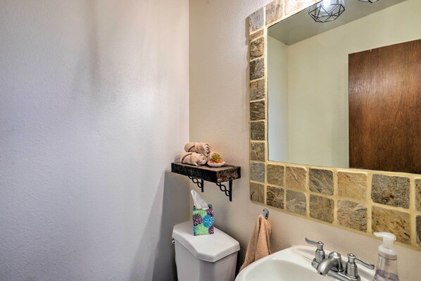 Une salle de bain équipée de toilettes, d’un lavabo et d’un porte-serviettes.
