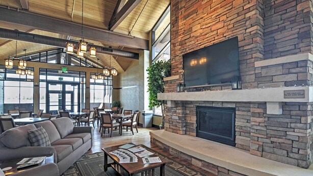 A spacious lobby with a fireplace, comfortable seating, and a large TV screen. - Deck & Resort Amenities: Arrowhead Lake Home! (Pocono Lake)