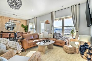 A modern living room with a brown leather sofa, a round coffee table, and a large mirror with lights. - Reeds Spring Condo ~ 3 Mi to Silver Dollar City! (Branson West)