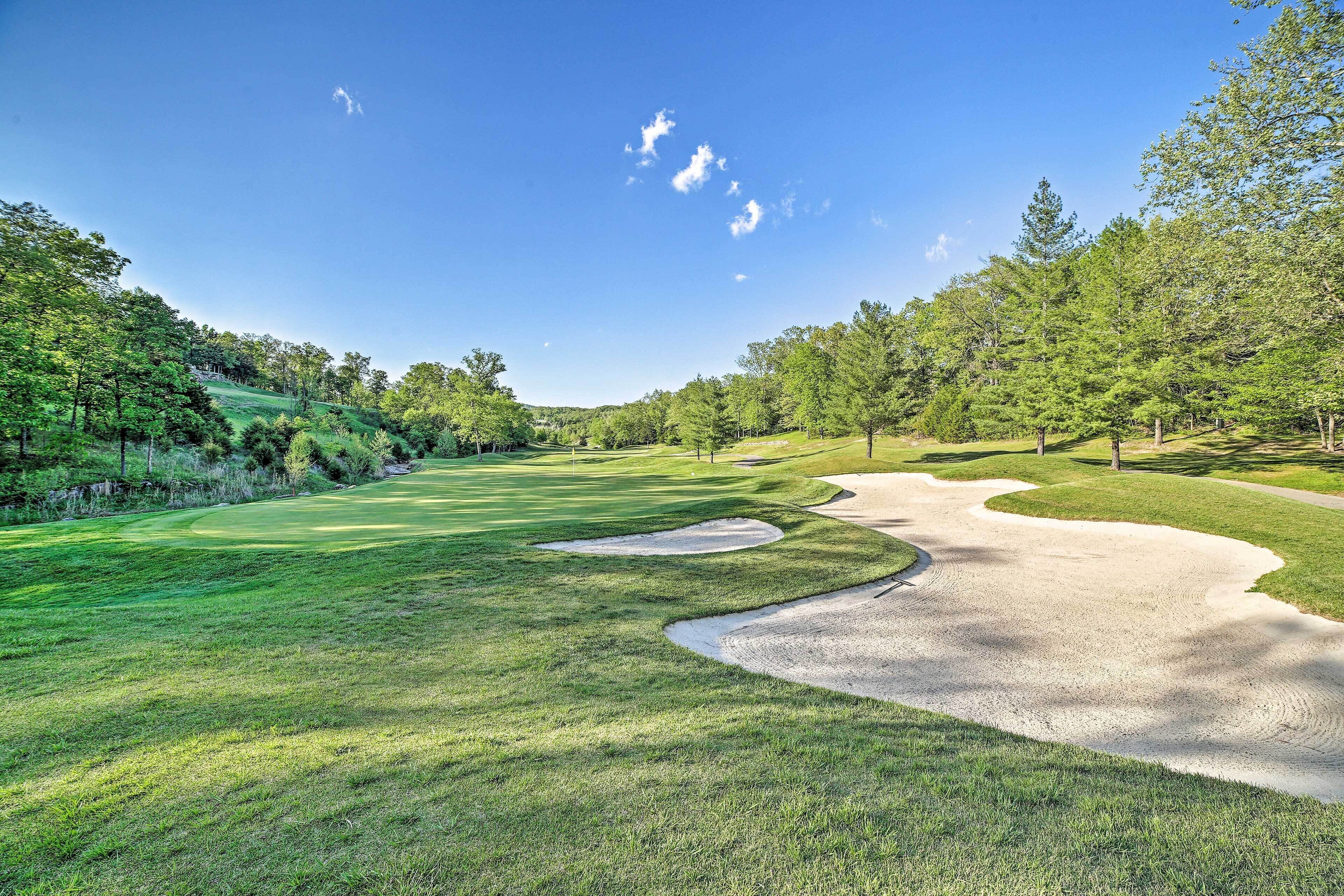 A golf course with a well-maintained fairway, sand bunkers, and lush greenery.
