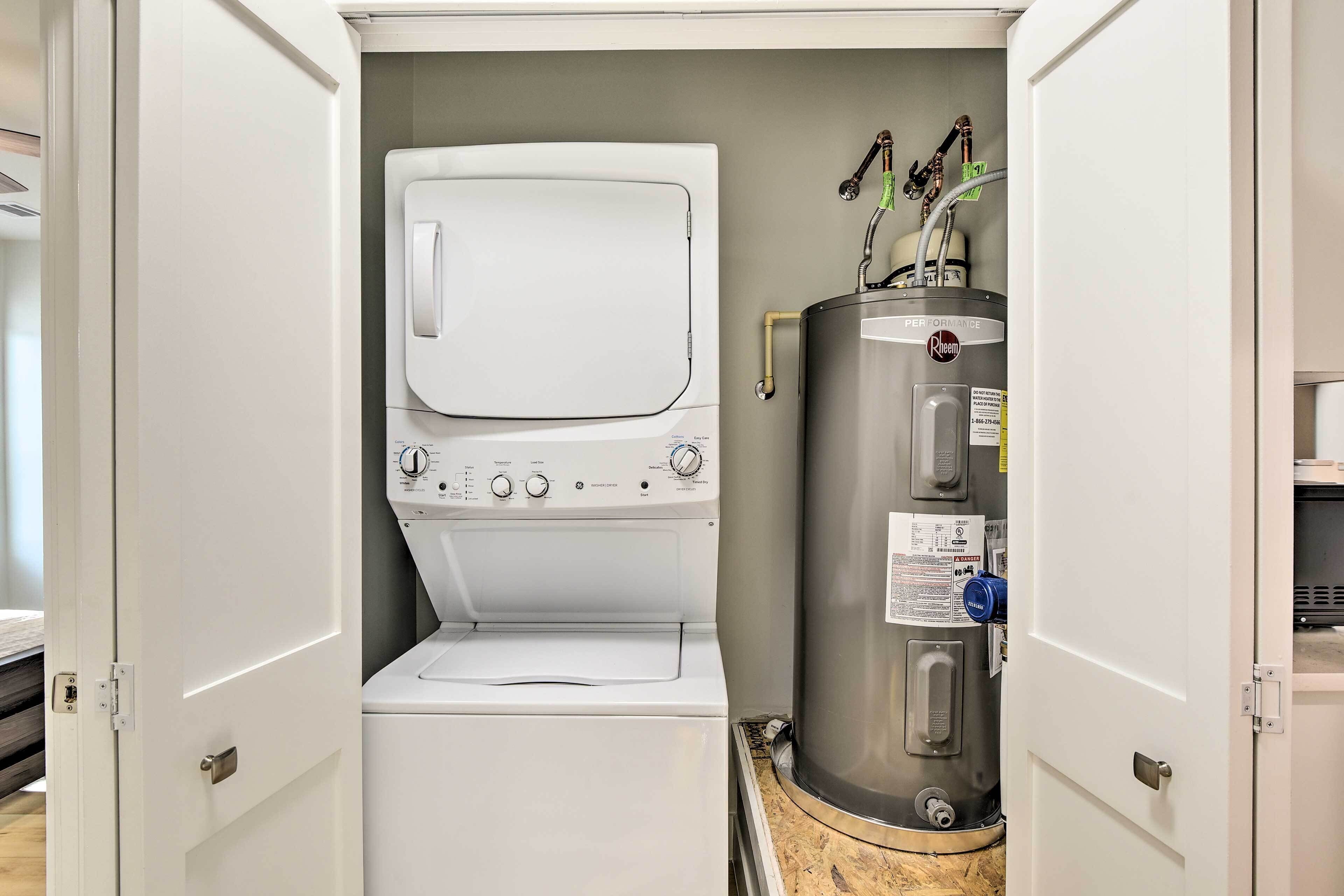 A compact laundry room with a washing machine, dryer, and water heater.