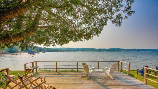 A wooden deck with outdoor seating and a view of a lake. - Waterfront Suttons Bay: Wine Trail, Pickleball Ct (Suttons Bay)