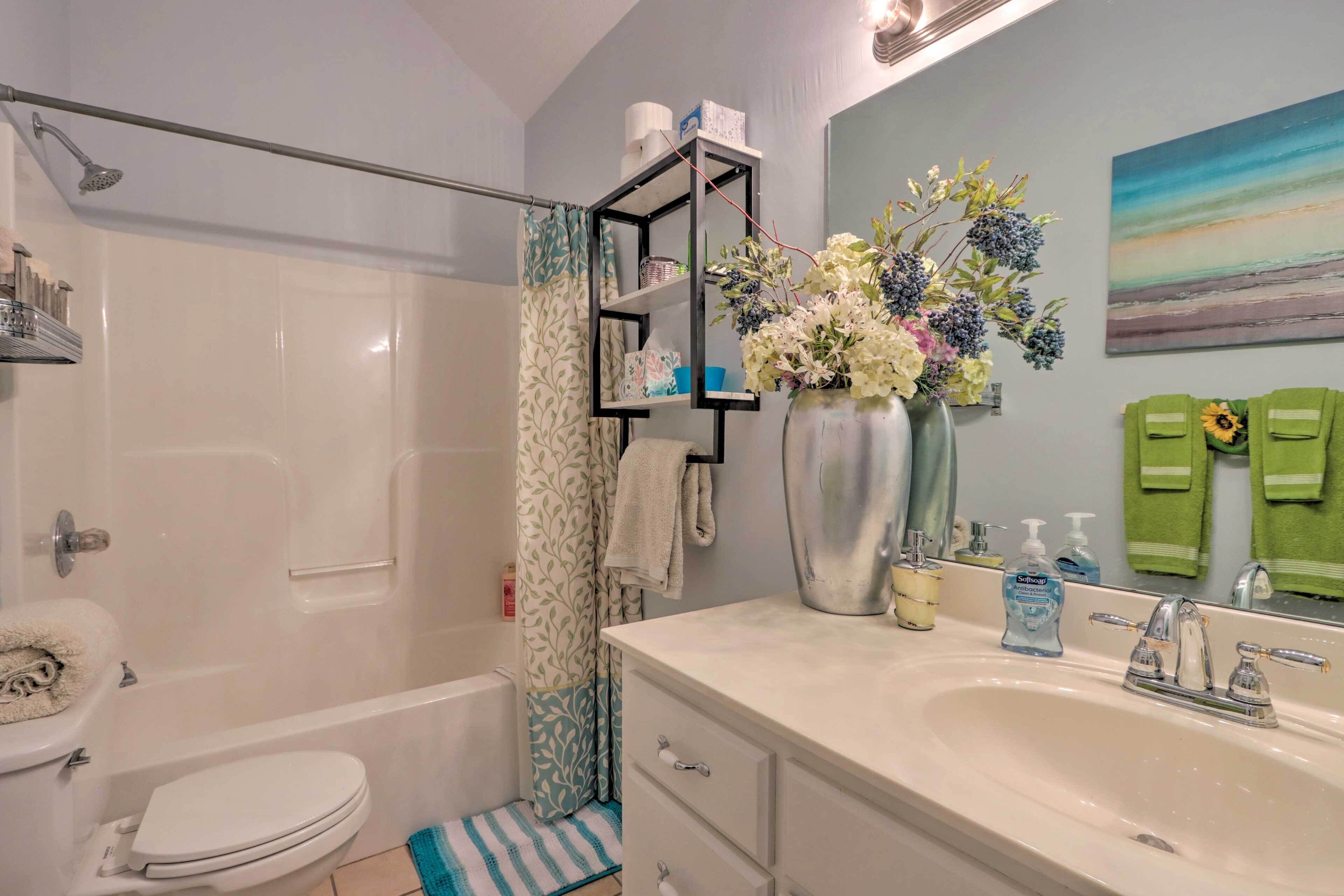 A bathroom with a bathtub, toilet, sink, and a shower.