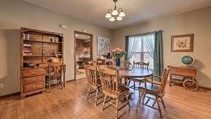 A dining area with a wooden table and chairs, a bookshelf, and a globe on a side table. - Historical West Mineral Escape w/ Porch! (West Mineral)