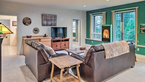 A living room with a fireplace, leather sofas, a coffee table, and a television. - Ketchikan Home: Bay Views, 1/2 Mi to Hiking Trails (Ketchikan)