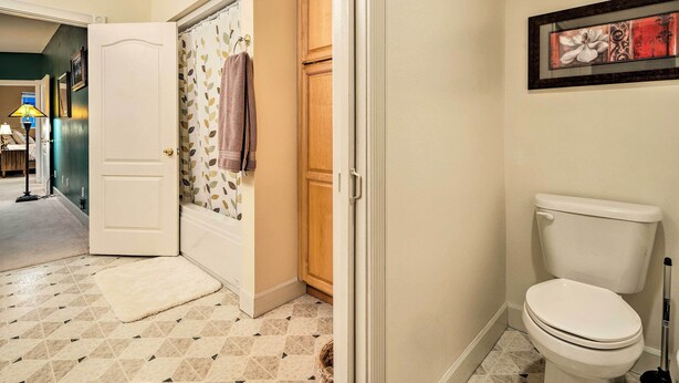 A bathroom with a toilet, a shower curtain, and a tiled floor. - Ketchikan Home: Bay Views, 1/2 Mi to Hiking Trails (Ketchikan)