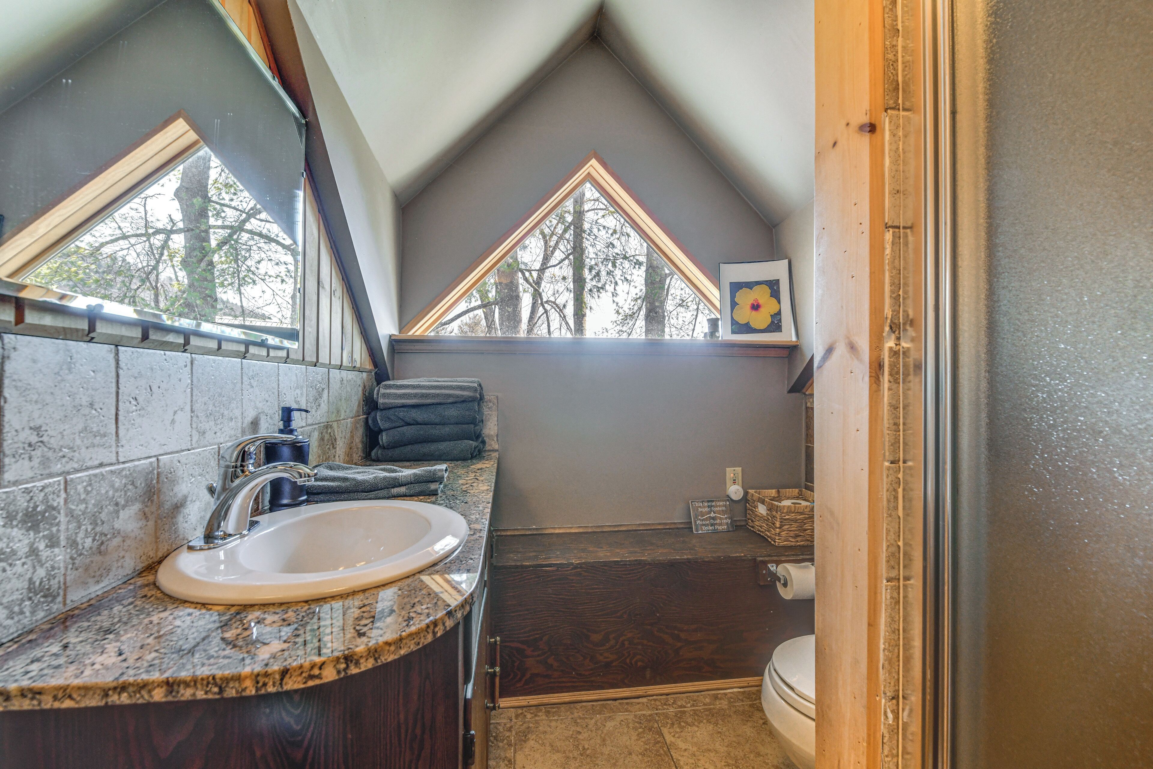 Une salle de bain avec un lavabo, un miroir et un meuble-lavabo en bois.