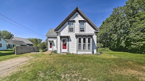 A two-story house with a red door, a front porch, and a well-maintained lawn. - Near Lakes, Bay & Trails! Historic Waldoboro Gem (Waldoboro)
