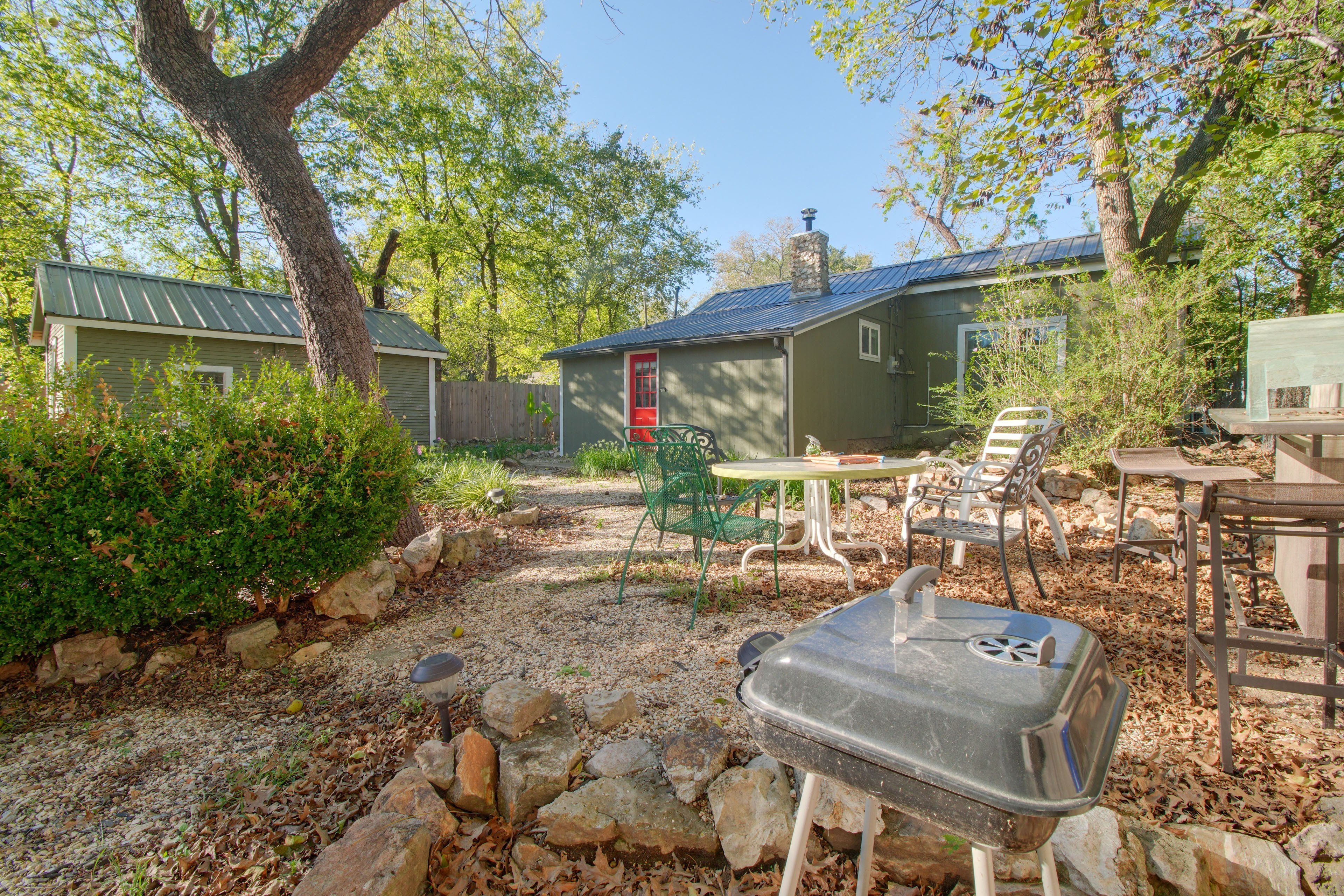 A backyard with a barbecue grill, outdoor furniture, and a small shed.