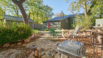 A backyard with a barbecue grill, outdoor furniture, and a small shed.