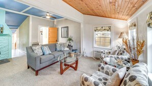 A living room with a gray sofa, a glass coffee table, and patterned armchairs. - Historic Cabin w/ Yard: 1 Mi to Lake Spavinaw! (Spavinaw)