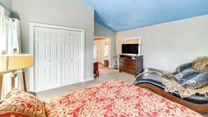 A bedroom with a bed, a ceiling fan, a dresser, and a television. - Historic Cabin w/ Yard: 1 Mi to Lake Spavinaw! (Spavinaw)