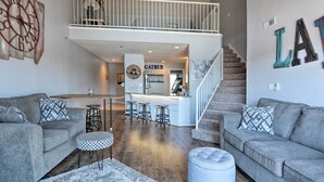 A spacious living area with a high ceiling, a mezzanine level, and a kitchen area. - Clifftop Kaiser Condo for Shootout Weekend Groups (Kaiser)