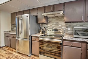 A modern kitchen with stainless steel appliances, including a refrigerator, oven, and microwave.