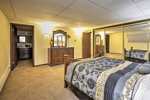A bedroom with a large bed, a dresser, a mirror, and a door leading to a bathroom. - Lakefront Fairbanks Unit, 1 Mile to Pioneer Park! (Fairbanks)