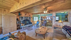 A wooden interior with a fireplace, a sofa, and a dining area. - Waterfront Lake Pleasant Getaway w/ Kayaks, Grill! (Lake Pleasant)