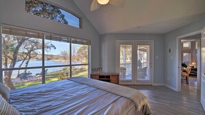 Ein Schlafzimmer mit einem großen Bett, einem Deckenventilator und Seeblick.