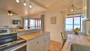 A kitchen with a large island, a stove, and a ceiling fan. There is a window with a view of the ocean. - Lakefront Sanctuary w/ Mount Konocti Views (Nice)