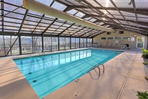 An indoor swimming pool with clear blue water, a covered roof, and a view of the surrounding area. - Indoor Pool Access: Golf Getaway Near 76 Strip! (Branson)