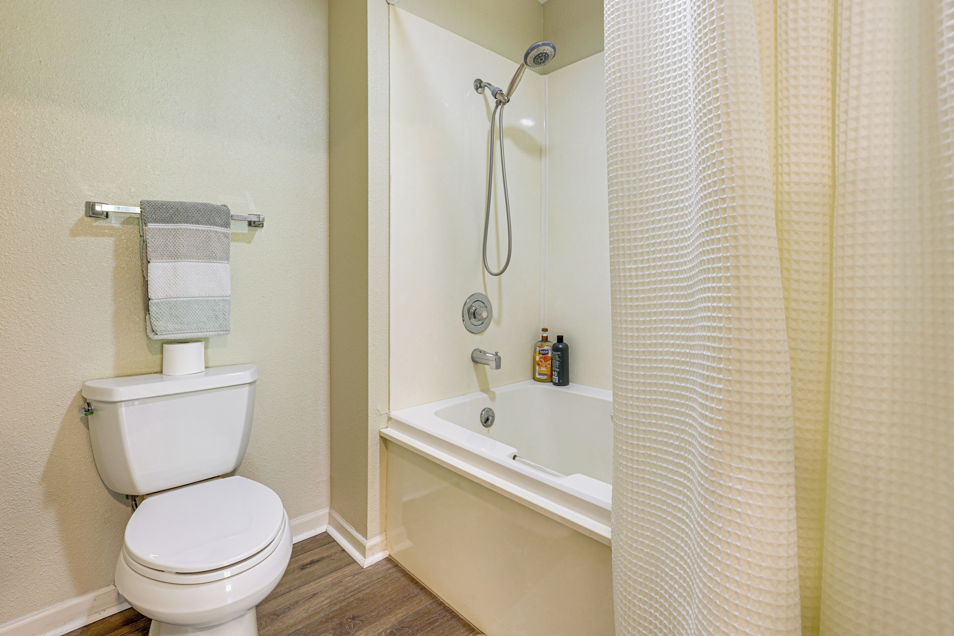 A bathroom with a toilet, a shower with a glass door, and a bathtub.