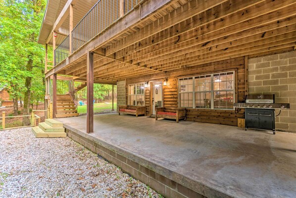 A wooden deck with outdoor seating and a grill area.