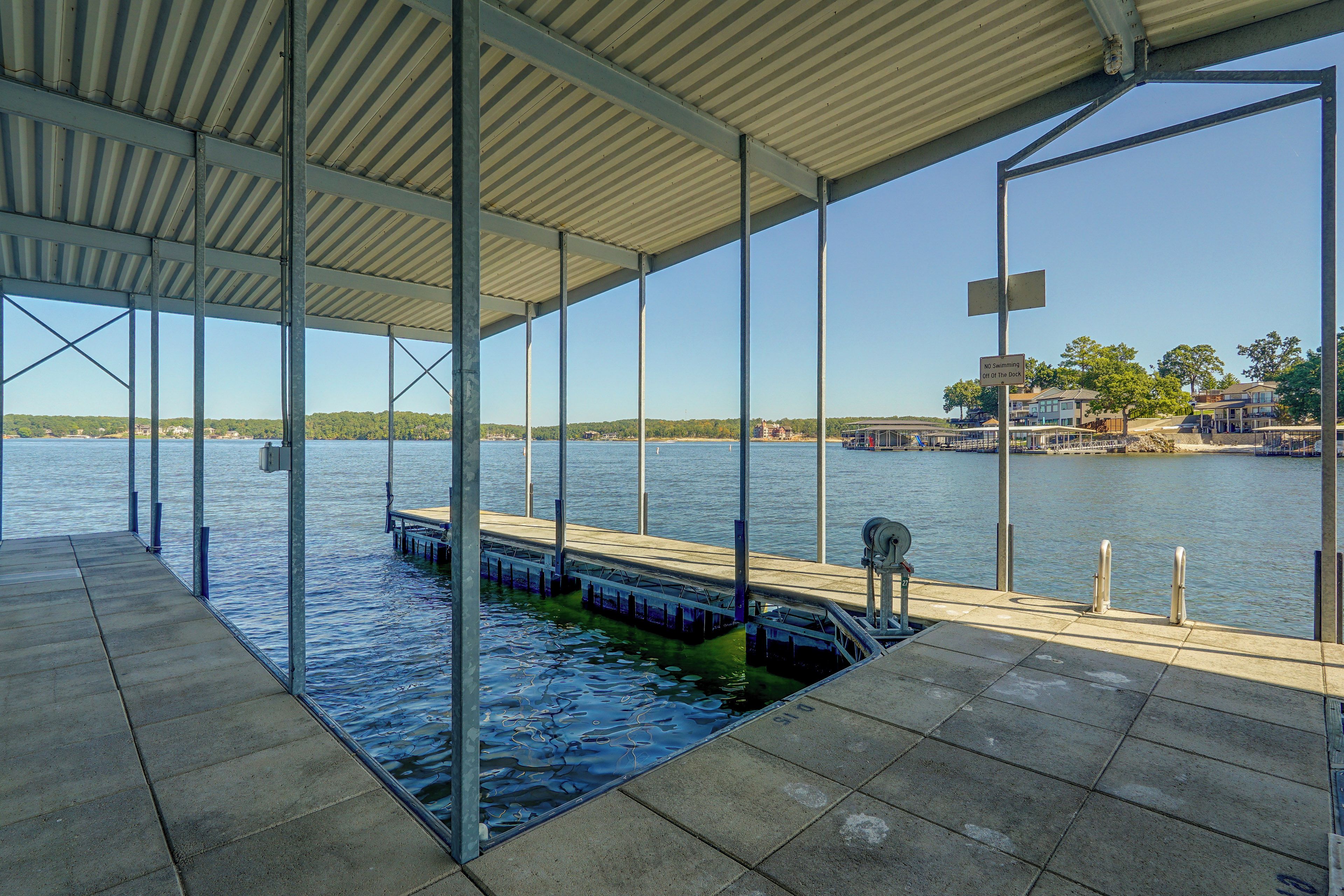 A covered dock area with a view of the water and a dock in the background.