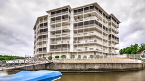 Un hôtel à plusieurs étages doté de balcons, un quai avec un abri pour bateaux et une vue sur le front de mer.