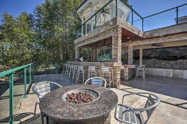 An outdoor patio area with a round table, chairs, and a fire pit.