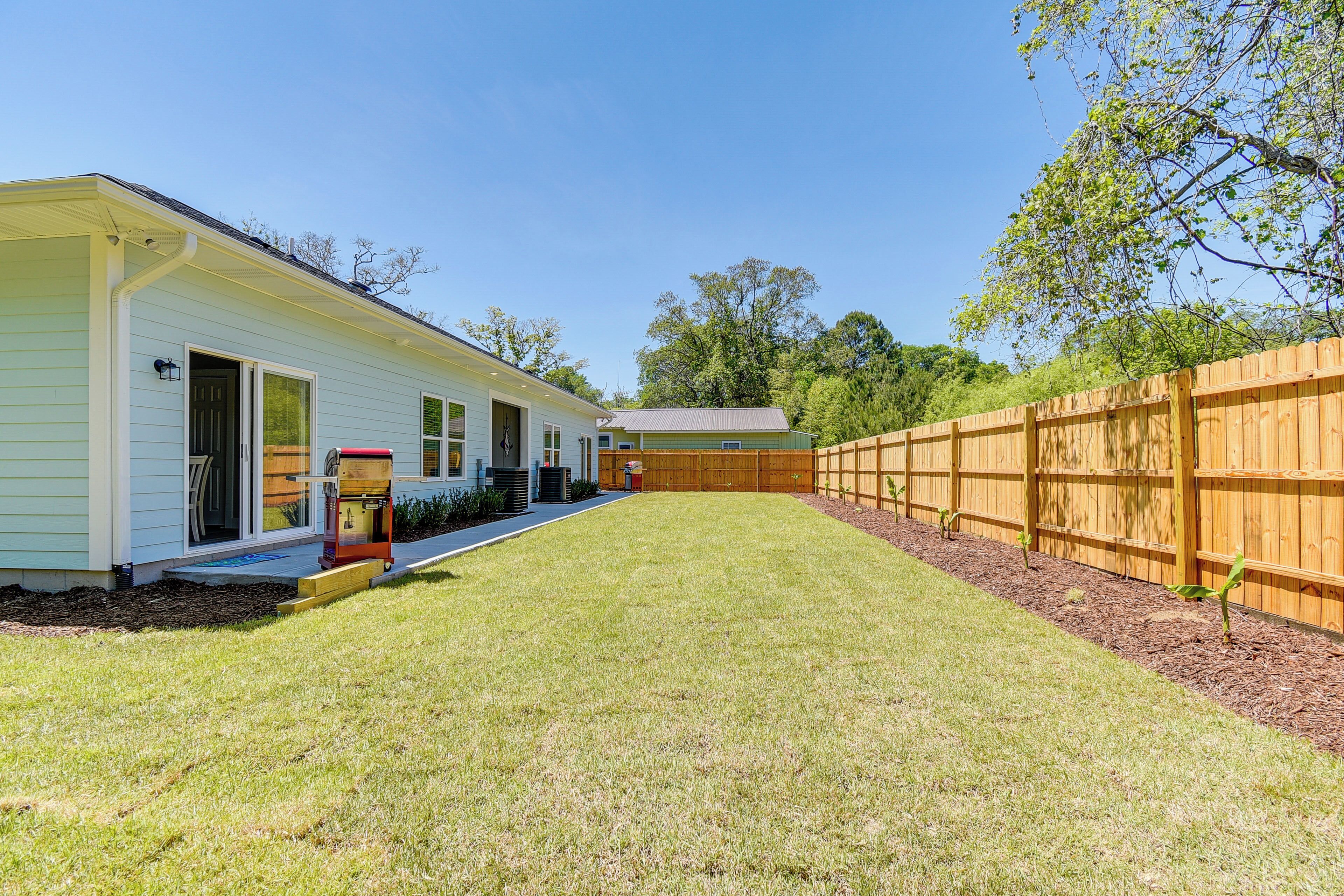A single-story house with a front porch, a small attached garage, and a wooden fence surrounding the yard.