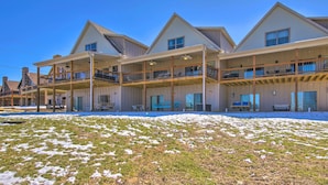 A multi-story hotel with a covered outdoor area and a snow-covered lawn. - Lampe Retreat w/ Pool Access - Walk to Lake! (Lampe)