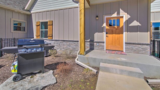 A house with a wooden door, a barbecue grill, and a stone pathway leading to the entrance. - Lampe Retreat w/ Pool Access - Walk to Lake! (Lampe)