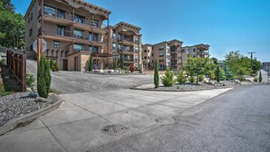 A multi-story residential building with balconies, a landscaped driveway, and a clear sky. - Manson Condo w/ Pool Access - Near Marina and Town (Manson)
