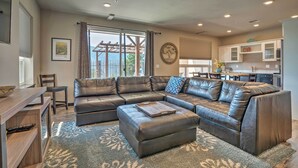A modern living room with a sectional sofa, a coffee table, and a dining area. - Manson Condo w/ Pool Access - Near Marina and Town (Manson)