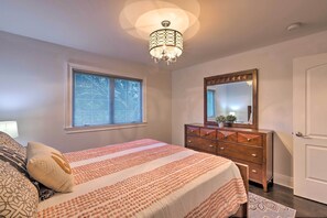A bedroom with a bed, dresser, mirror, window, and ceiling light. - 25 Mi to Nyc: Walkable Long Island Apt w/ Balcony (Glen Cove)