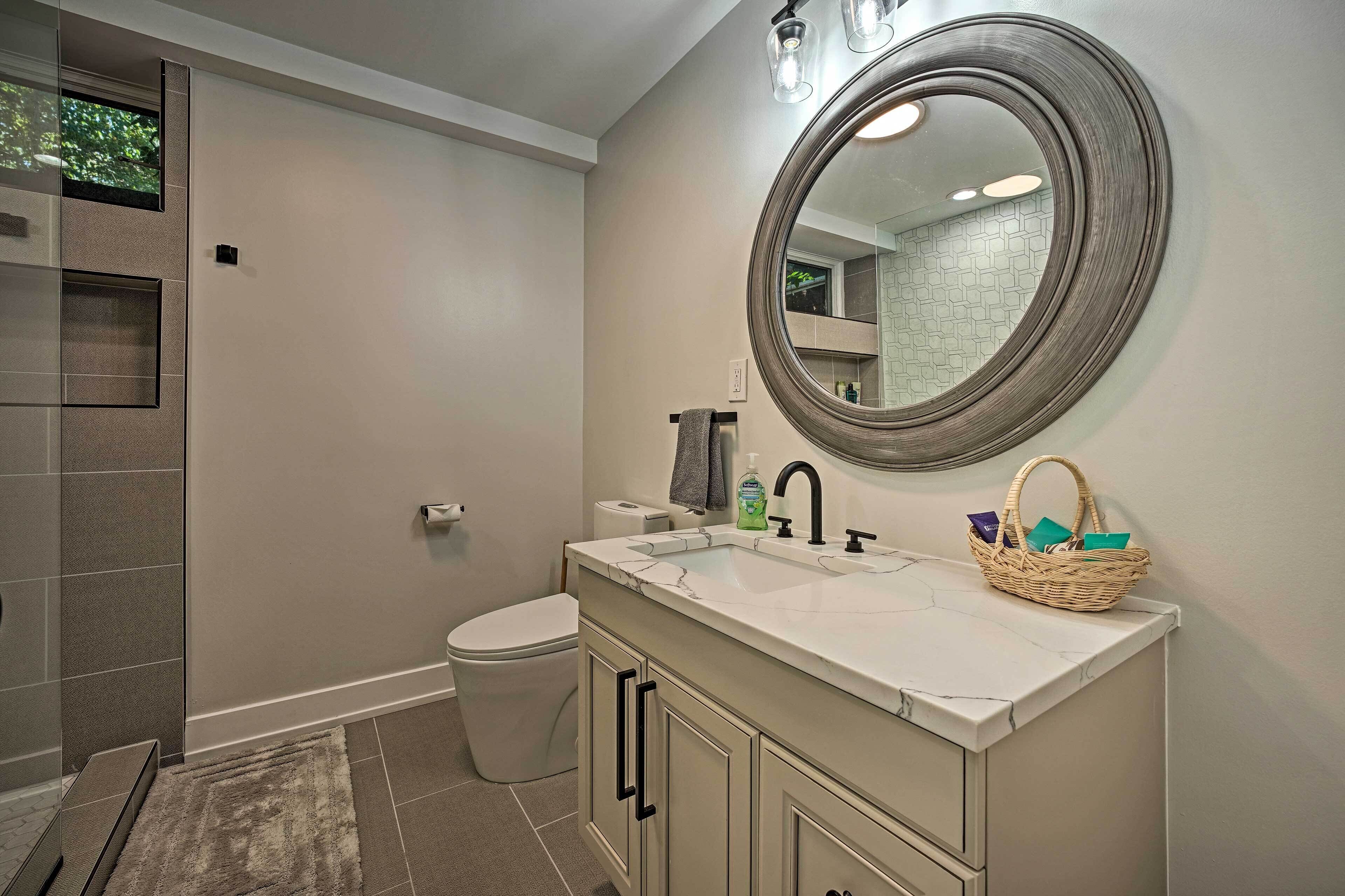 A bathroom with a large mirror, a sink, and a toilet.