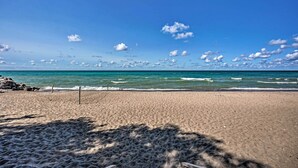 Una playa con cielos despejados y olas tranquilas.