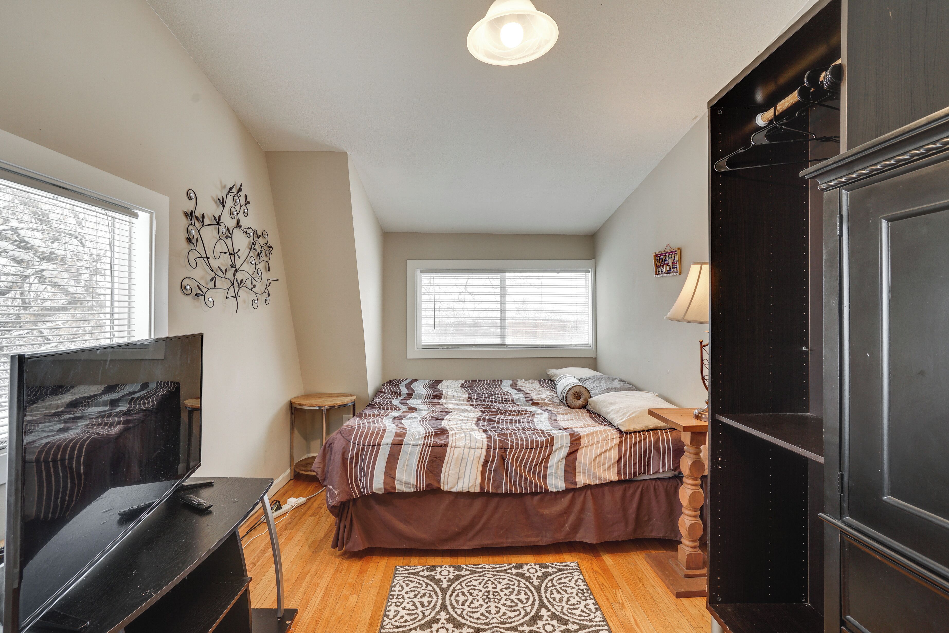 A bedroom with a bed, TV, and a wardrobe.