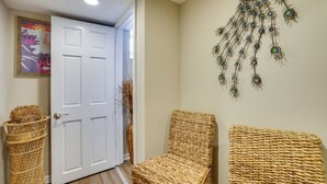 A hallway with a white door, wicker chairs, and a wall hanging. - Families w/ Pets! Home 8 Mi to Dtwn Minneapolis (Golden Valley)