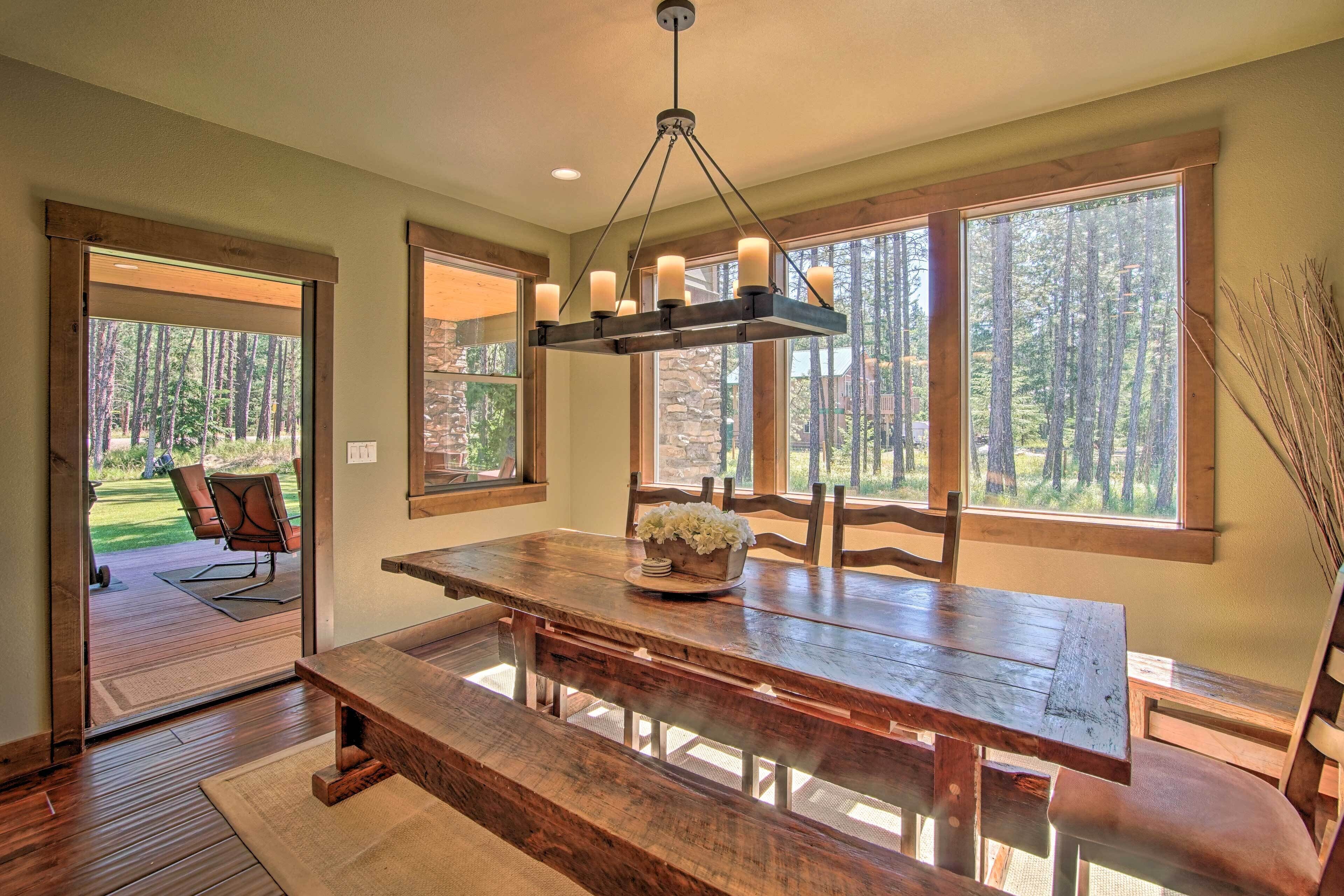 A dining area with a wooden table, benches, and a chandelier.
